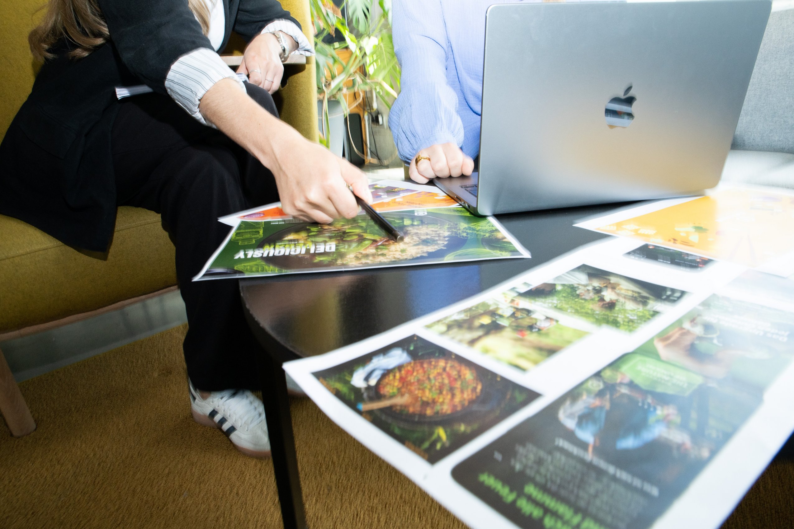 Nahaufnahme von zwei Personen am Tisch, die Konzepte für nachhaltige Ernährung und pflanzliche Produkte besprechen.