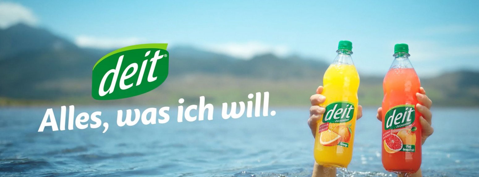 Key Visual: Zwei Hände heben zwei Flaschen Deit aus dem See.