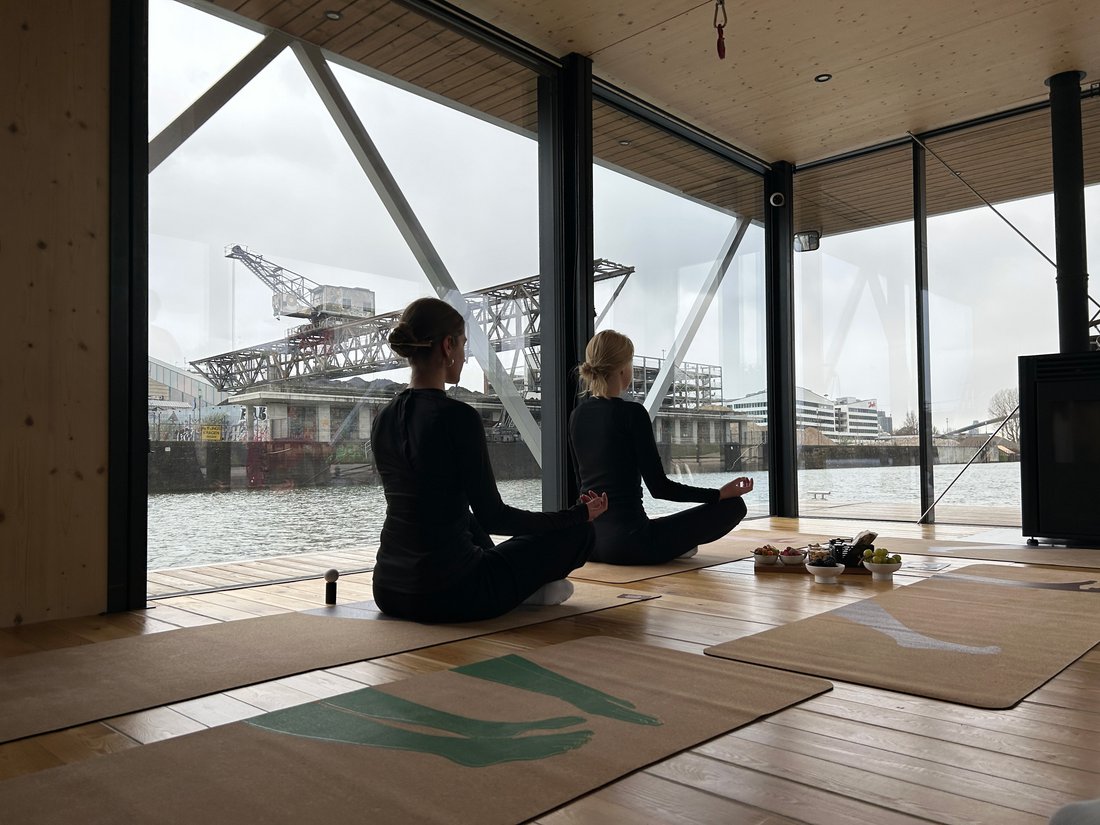 Zwei Kolleginnen beim Yoga auf dem Hausboot in unmittelbarer Nachbarschaft zur Agentur.