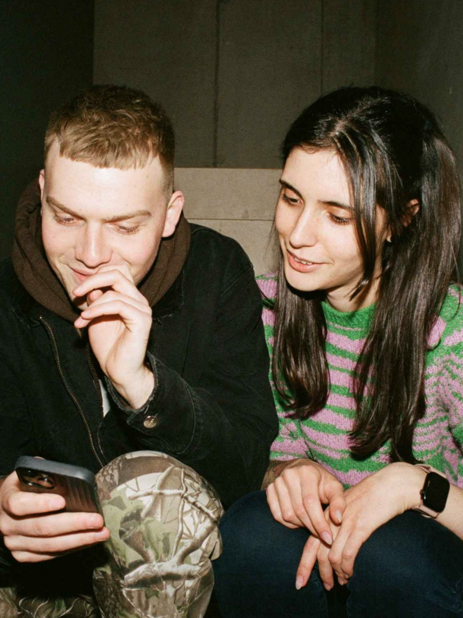 Closeup auf einen jungen Mann und eine junge Frau der Gen Z, die gemeinsam auf etwas schauen.